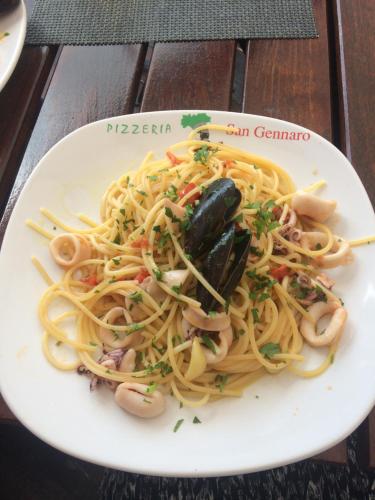 a plate of pasta with shellfish on a table at Pensiunea San Gennaro in Miercurea-Ciuc