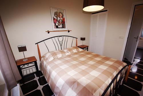 a bedroom with a bed with a checkered blanket at Logies Taverne nearby Roermond, Thorn en Weert in Kelpen-Oler