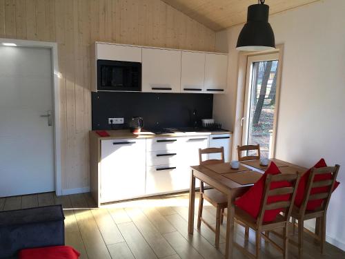 a kitchen with a table and a kitchen with white cabinets at 3pokoje - Domek lub Pokój pod lasem na odludziu, jacuzzi, sauna, kominek, Roztocze in Susiec