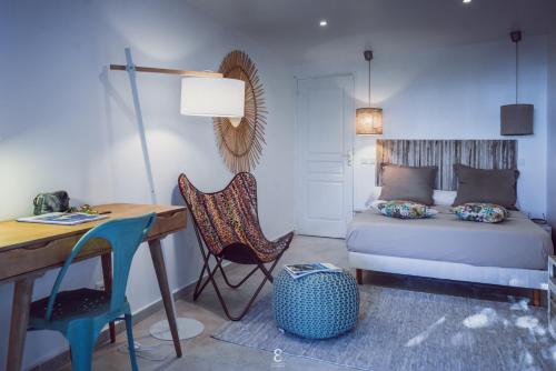 een slaapkamer met een bed en een bureau bij Villa d’ô in Majikavo Koropa