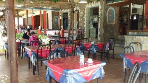 un restaurant avec des tables, des chaises et des nappes rouges et bleues dans l'établissement Amaliahotel, à Apolakkiá