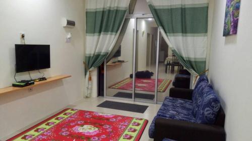 a living room with a couch and a tv at HOMEMuslim GAMBANG in Kampong Pohoi