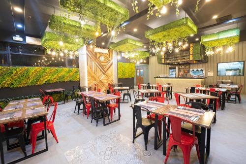 a dining room with tables and chairs and lights at Axiaa Hotel in Manila
