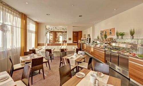 a restaurant with tables and chairs and a buffet at Hotel Süd Graz in Graz
