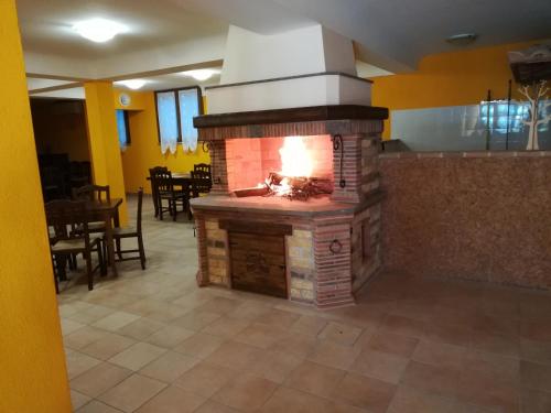 a brick fireplace in a room with a dining room at Agriturismo Isola Verde in SantʼUrbano