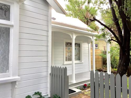 a white house with a white picket fence at G- HOUSE (CH-CH) in Christchurch