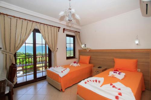 two beds in a room with a balcony at Akyaka Deger Apart in Akyaka