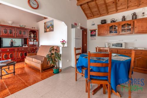 a kitchen and living room with a table and a couch at Casa do Tio Jose in Doze Ribeiras