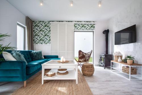 a living room with a blue couch and a table at Brzozowa Przystań in Władysławowo