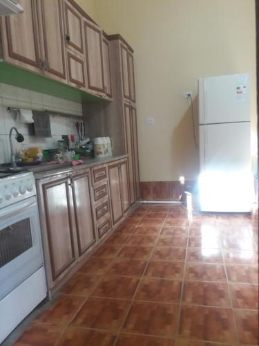 una cucina con frigorifero bianco e armadietti in legno di Hotel-129 a Samarkand