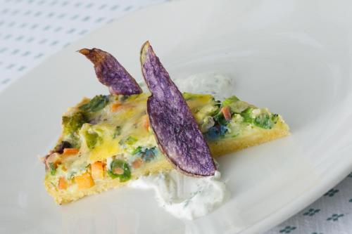 two pieces of pizza on a plate with whipped cream at Biohotel Eggensberger in Füssen