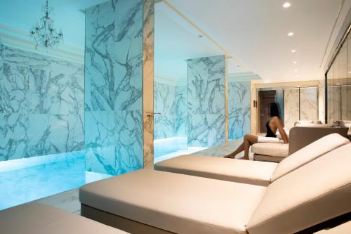 Cette chambre comprend un lit et un mur en marbre. dans l'établissement Le Damantin Hôtel & Spa, à Paris