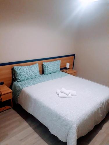 a bedroom with a bed with two white towels on it at Country House Paola in Marina di Gioiosa Ionica