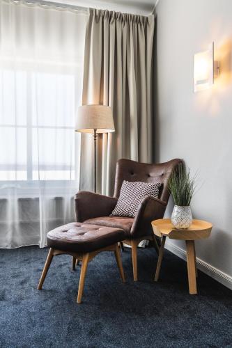 a living room with a chair and a table at Dalecarlia Hotel & Spa, BW Premier Collection in Tällberg