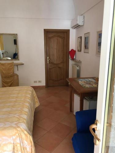 a room with a bed and a table and a door at La Mammola in Positano