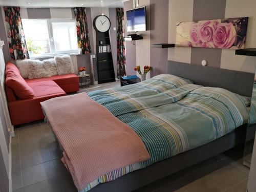 een slaapkamer met een bed en een bank bij Studio Callanya in Callantsoog