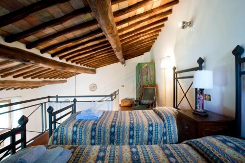 - une chambre avec 2 lits dans une pièce dotée de plafonds en bois dans l'établissement La Pergola, à Castellina in Chianti