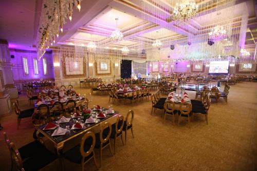 a large banquet hall with tables and chairs and chandeliers at Rehana Plaza Hotel in Cairo