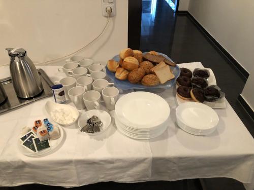 a table with plates and cups of food on it at Pension Laatzen in Hannover