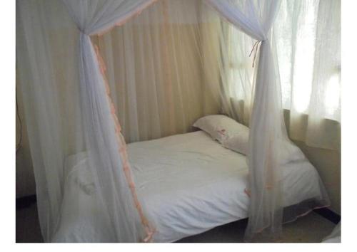 a white bed with a canopy in a room at Hotel Jaffers Nairobi in Nairobi
