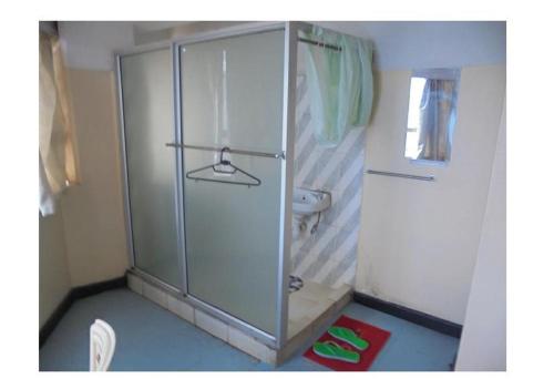 a bathroom with a shower with a sink and a toilet at Hotel Jaffers Nairobi in Nairobi