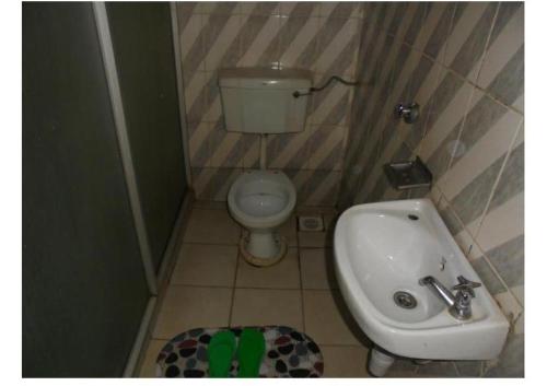 a small bathroom with a toilet and a sink at Hotel Jaffers Nairobi in Nairobi