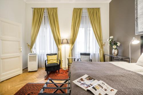 a bedroom with a bed and a chair and windows at Da Vinci Art Home in Budapest