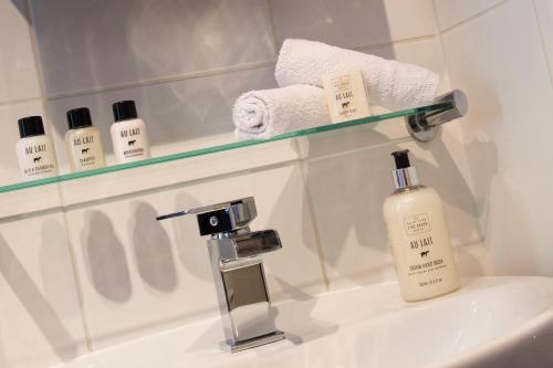 a bathroom sink with a bottle of lotion and a mirror at Grassmarket Old Town Boutique Apartment in Edinburgh