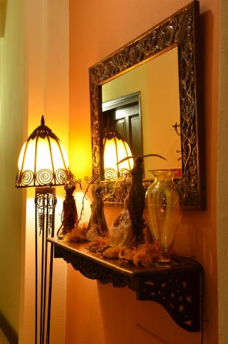 a mirror and a lamp on a shelf in a room at Atrion Highland Hotel in Elatochori