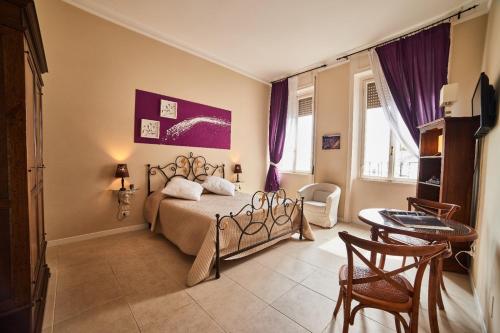 - une chambre avec un lit, une table et des chaises dans l'établissement Palazzo Frigo, à Montefiascone