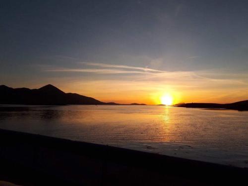 a sunset over a body of water with the sun setting at Cluain Abhainn 2-4 guests, private entrance in Westport