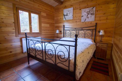 sypialnia z łóżkiem w drewnianym domku w obiekcie Paraiso Rural w mieście Villanueva de Cameros