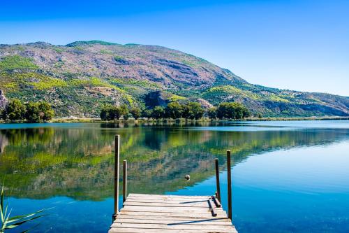 a dock on a lake with a mountain in the background at VILLA ELENI in Zakharo