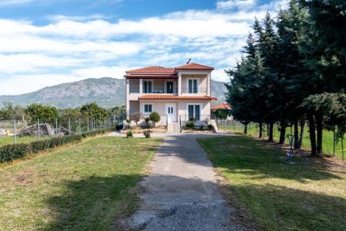 a large white house with a pathway in front at VILLA ELENI in Zakharo