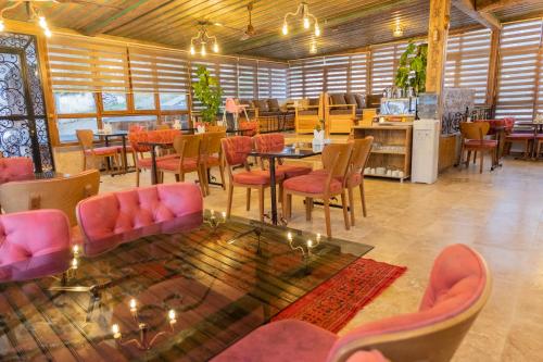 a restaurant with pink chairs and tables in a room at Grand Elite Cave Suites in Goreme