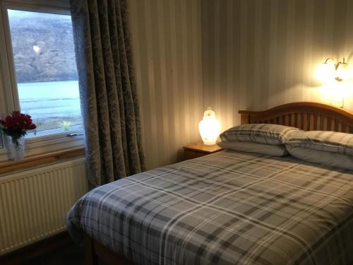 una camera da letto con un letto e una finestra con vista di Alltonside Guest House a Fort William
