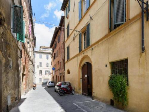 un coche aparcado en un callejón entre dos edificios en Casa di Osio - Porta Romana, en Siena
