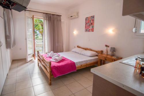 a small bedroom with a bed and a kitchen at Myloi Loggou in Sikia