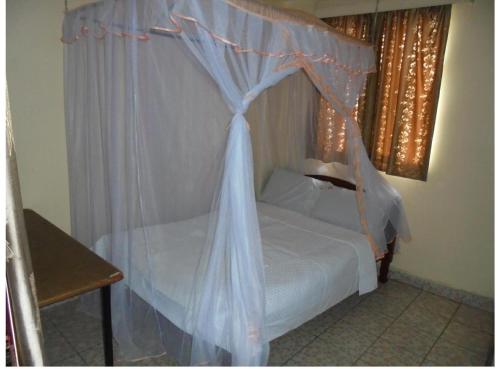 a bedroom with a bed with a canopy at Hotel Jaffers Nairobi in Nairobi