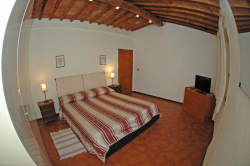 a bedroom with a bed and a flat screen tv at Agriturismo I Poggi in Impruneta