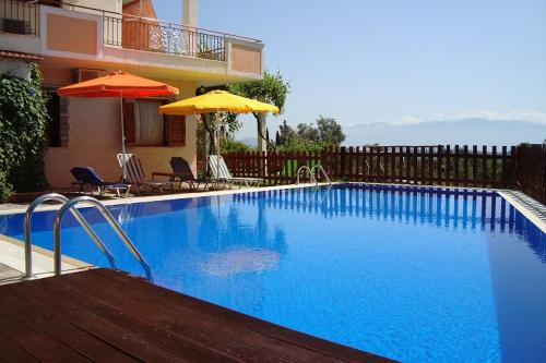 a large blue swimming pool next to a building at Villa's ground floor apartment with 60 qm swimming pool in Palaiokatoúna