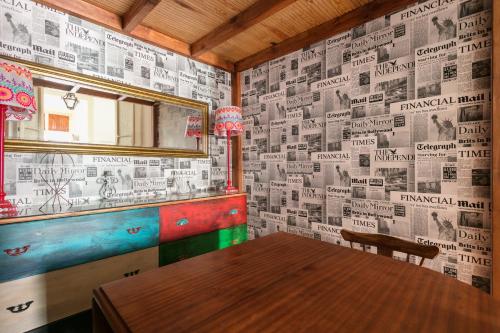 een eetkamer met een tafel en een muur bedekt met kranten bij FLH Rossio's Flat in Lissabon