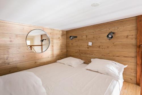 een slaapkamer met een wit bed en een spiegel bij FLH Rossio's Flat in Lissabon