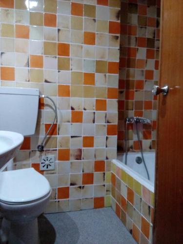 a bathroom with a toilet and a bath tub at Residencial Habimar in Sines