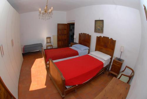 a bedroom with two beds and a chandelier at Agriturismo I Poggi in Impruneta