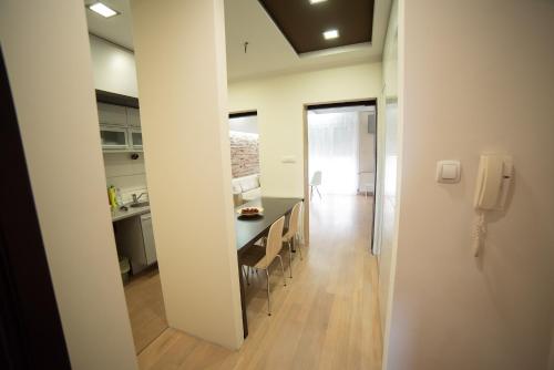 une cuisine et une salle à manger avec une table et un téléphone dans l'établissement Apartment Milos, à Novi Sad