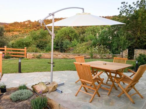a table and chairs under an umbrella on a patio at Aria Monte Villas in Raches
