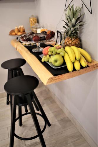 een tafel met een fruitschaal en twee barkrukken bij B&B i Maestri in Napels