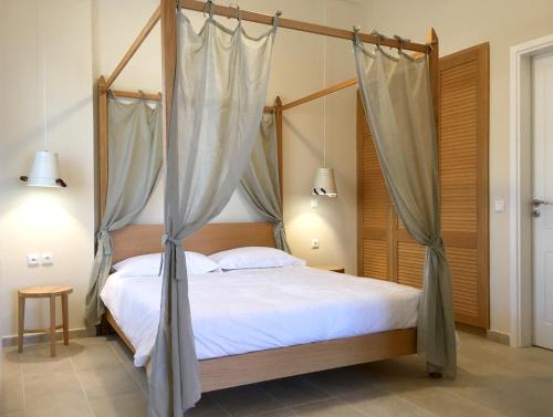 a bedroom with a four poster bed with mosquito nets at Aria Monte Villas in Raches