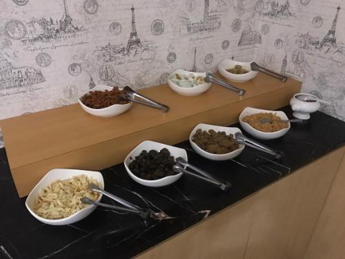 a buffet with bowls of food on a table at Discovery Motel - Nangang臺北市旅館349-2號 in Taipei